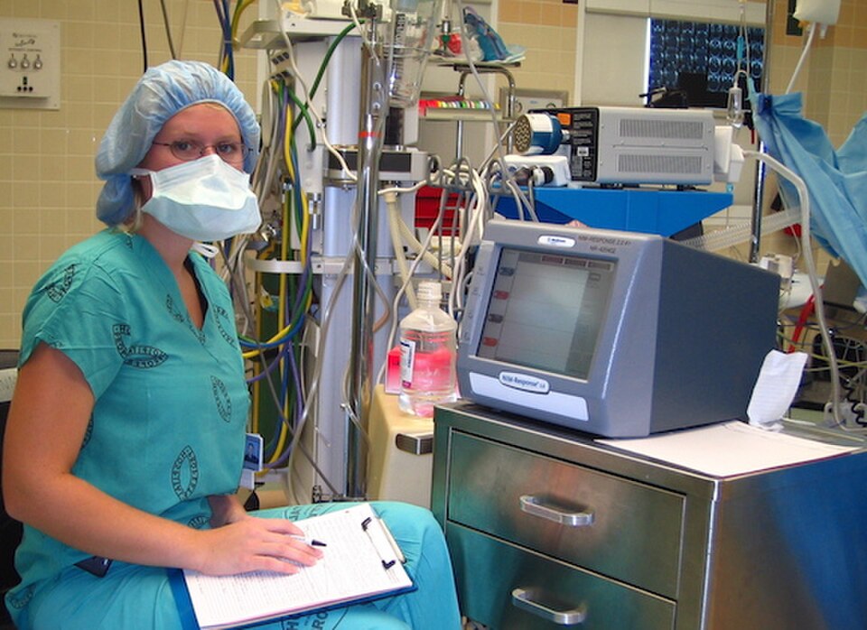 Technologist at an intraoperative nerve-monitoring station in an operating room